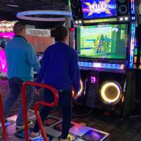 Two alumni competing in dance game